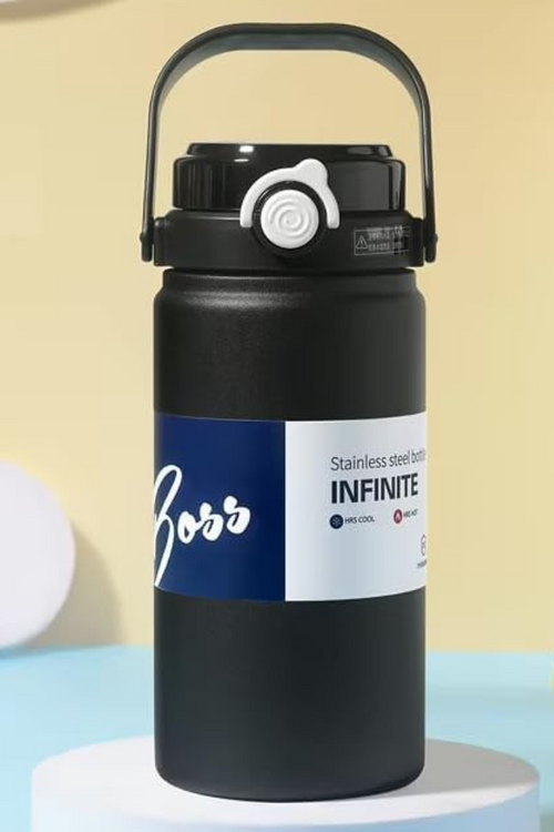 Black water bottle with a label on a light blue surface and beige background